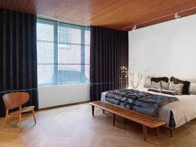 Ein modern eingerichtetes Schlafzimmer mit braunen Vorhängen aus Chenille sowie blauen transparenten Schiebegardinen.