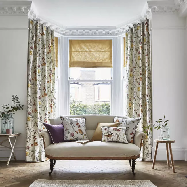 Altbau-Wohnzimmer mit Erker und Vorhängen in beige floralen Mustern