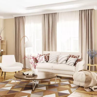 Ein gemütliches Wohnzimmer mit weißem Sofa und Sessel, beigefarbenen Vorhängen und weißen Gardinen an den Fenstern