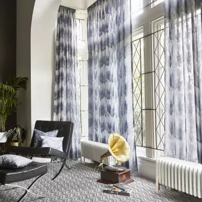Erkerfenster mit tintenblauem Vorhang, Grammophon und Barcelona-Stuhl.