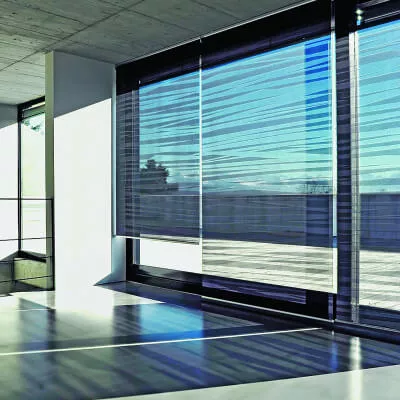 Halbtransparente Stoffrollos mit unregelmäßigen schwarzen Streifen hängen in einem modernen Ambiente.