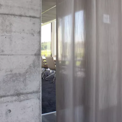 Ein modernes Büro mit einem transparenten grau-beigen Akustikvorhang.