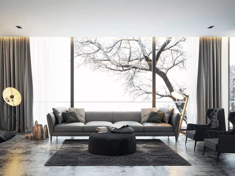 Ein luxoriöses Wohnzimmer mit grauen Möbeln vor einer großen Fensterfront mir grauen Vorhängen